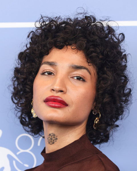 Closeup shot of Indya Moore with a curly wolf cut